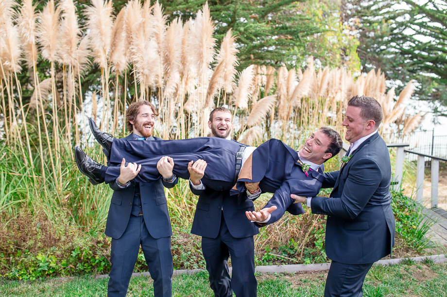 groomsmen carrying groom