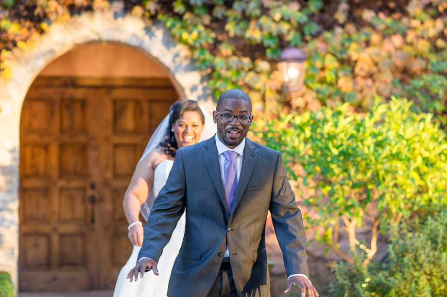 bride approaching groom from behind for first look