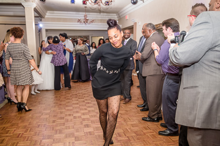 wedding guest in black dress dancing