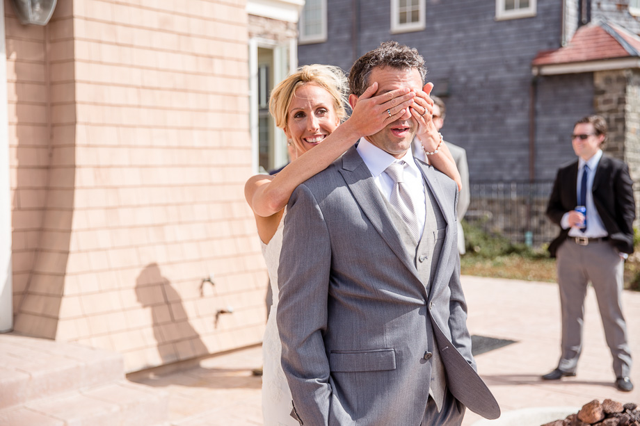 bride covering up groom's eyes before first look