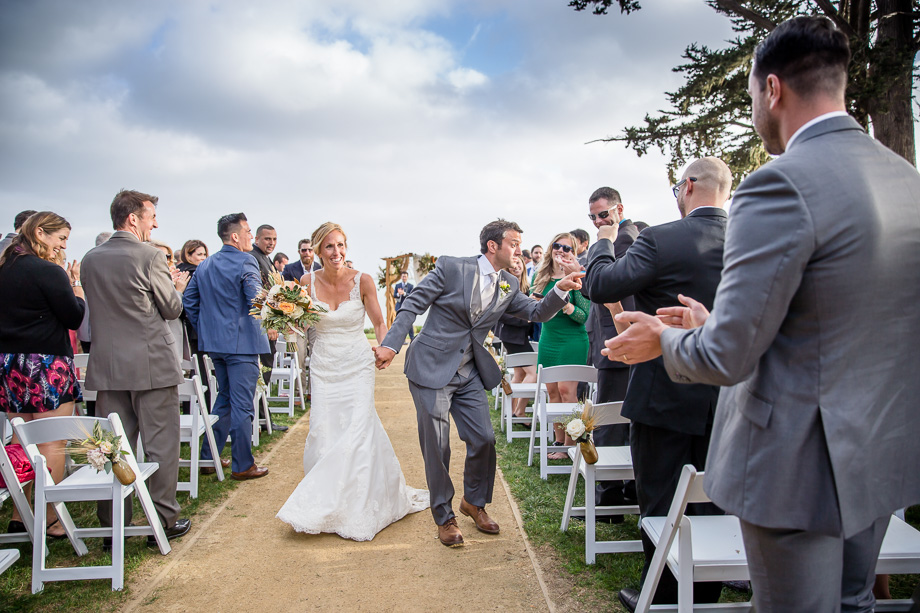 bride and groom walking up the aisle after wedding ceremony very happy