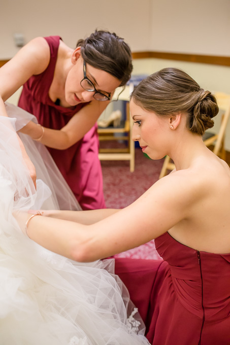 bridesmaids helping with bustling the dress