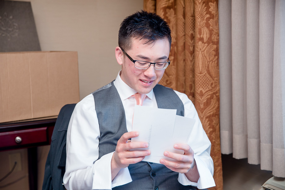 groom enjoying some boudoir photos of his fiancee