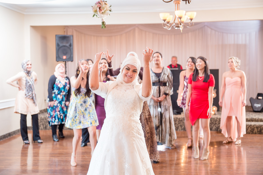 bride wearing hijab tossing her bouquet at the single ladies