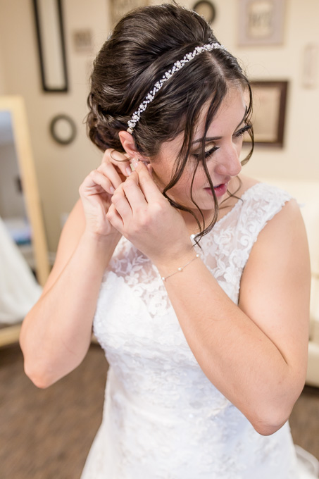 bride putting on earrings