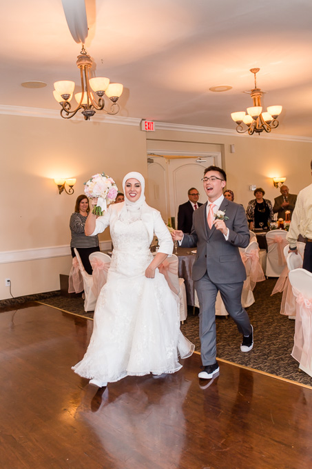 bride and groom running onto the dance floor
