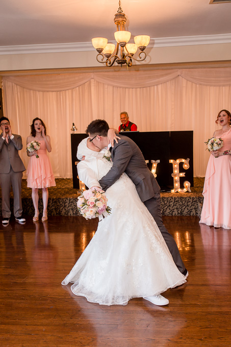 bride and groom dip and kiss