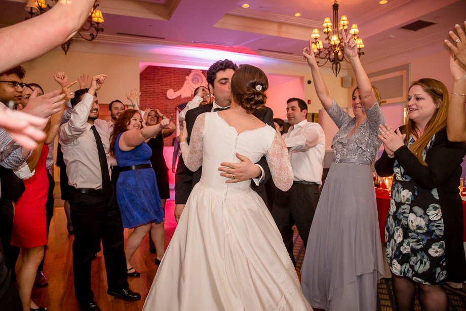 bride and groom kissing with guests cheering them on