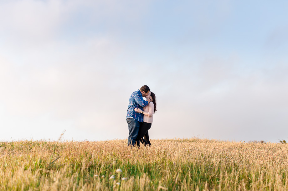 romantic grassy field sunset engagement photo