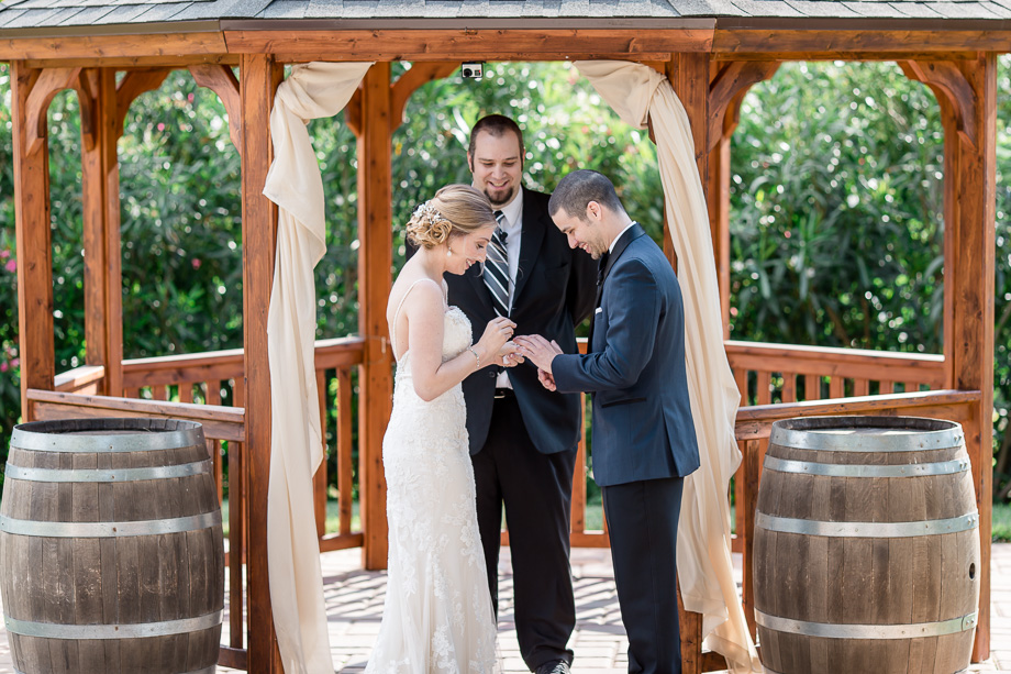 wedding ceremony ring exchange between wine barrels