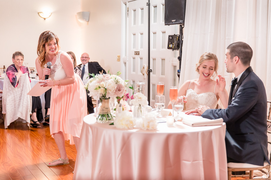 bride at head table laughing at funny bridesmaid toast