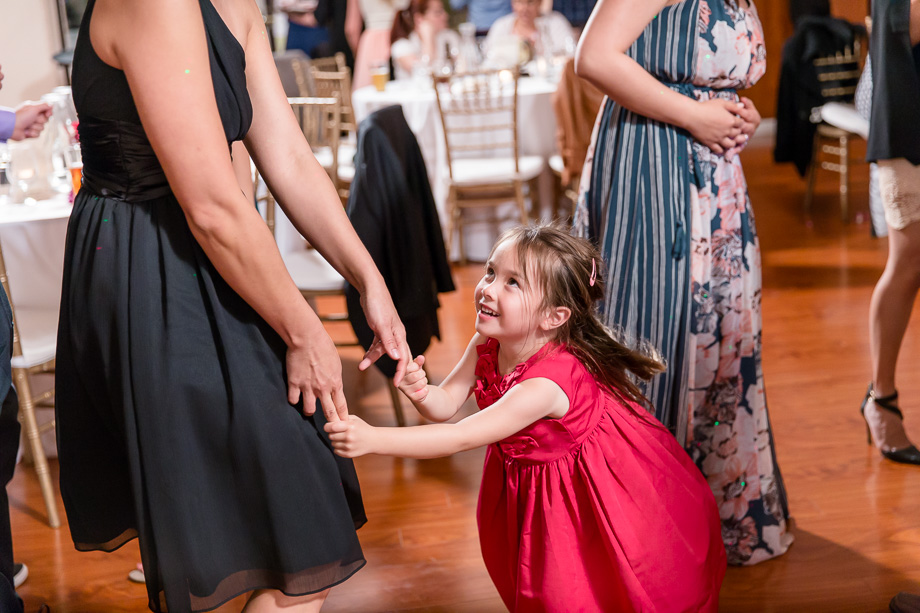 cute girl in red dress dancing during wedding reception