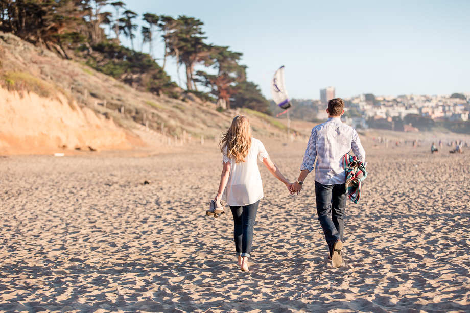 candid walking engagement photo on a beach
