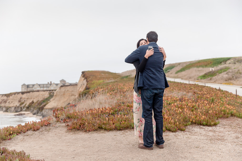 a sweet hug after she said yes to his proposal at half moon bay ritz carlton