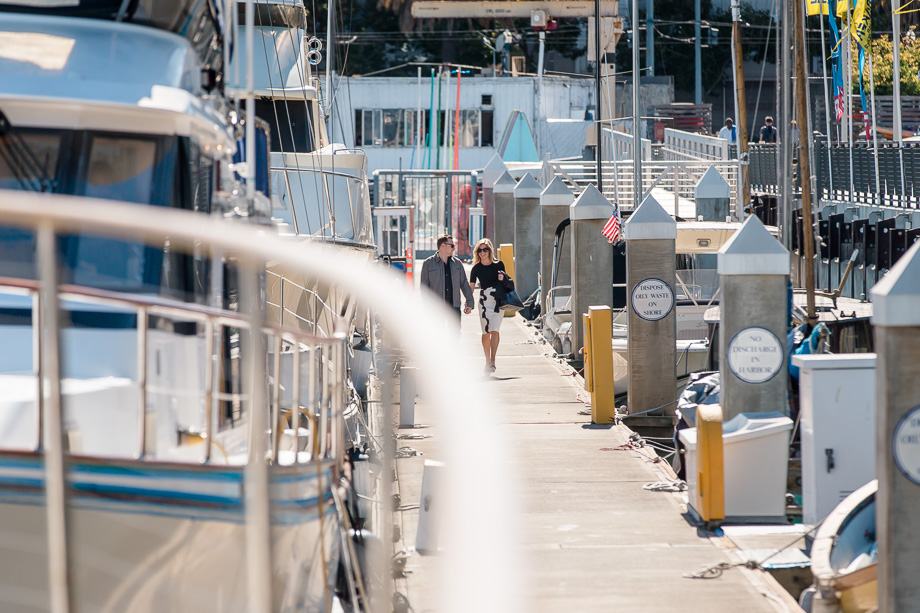 soon to be engaged couple walking on the pier approaching the boat