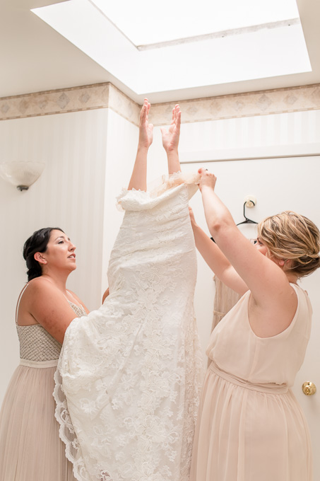 cute and funny photo of bride getting into her wedding gown