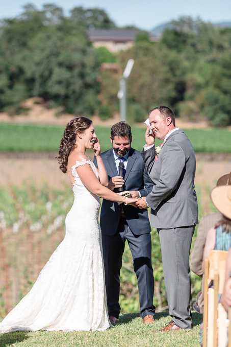 bride and groom wiping their happy tears at the same time