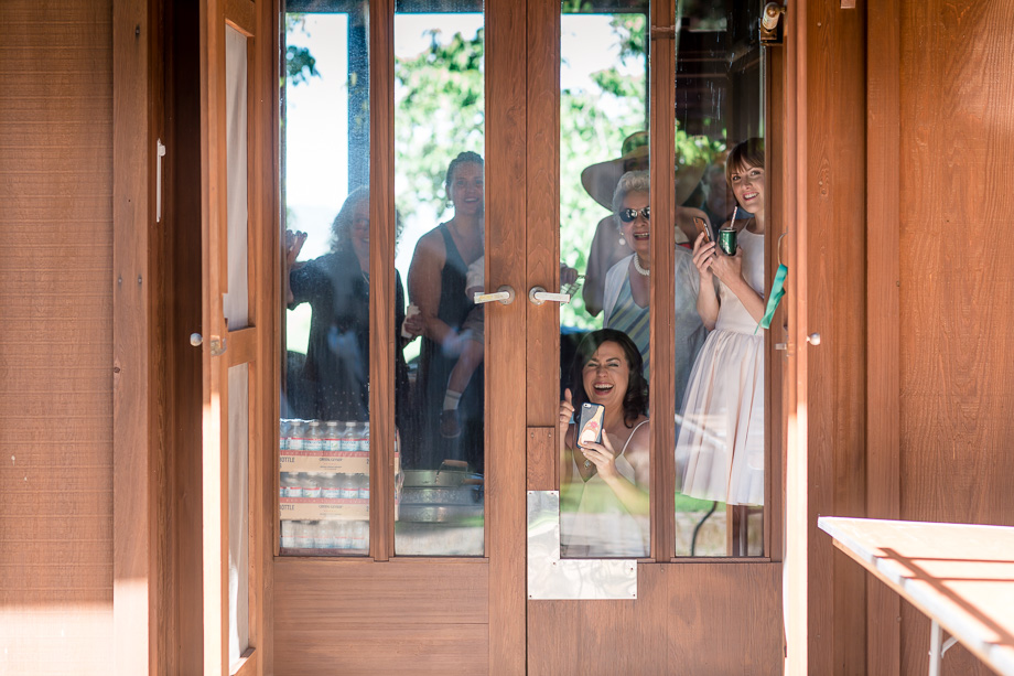bridal party and family watching the first look from inside the building
