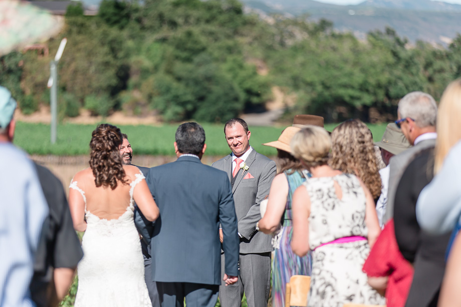 groom watching his bride walking down the aisle