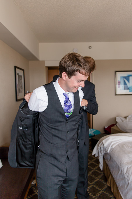 groom putting on his jacket