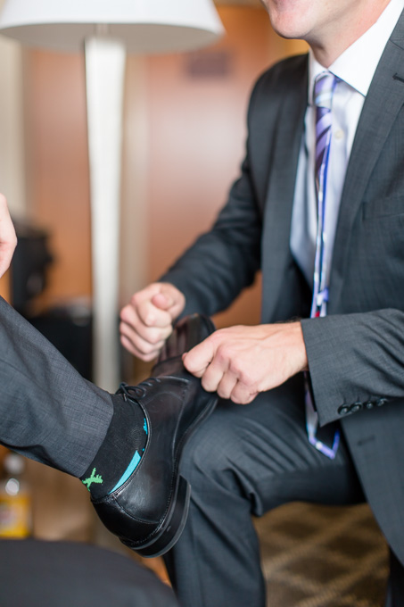 best man helping the groom to put on his shoes
