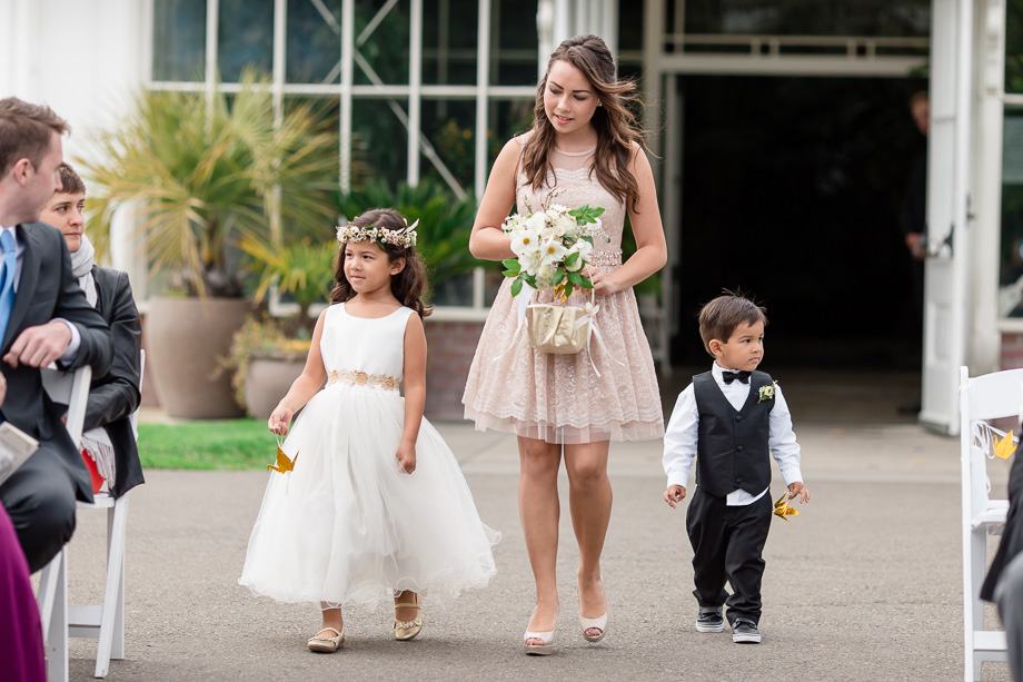 ring bearer and flower girl handing out golden origami cranes instead of flower petals