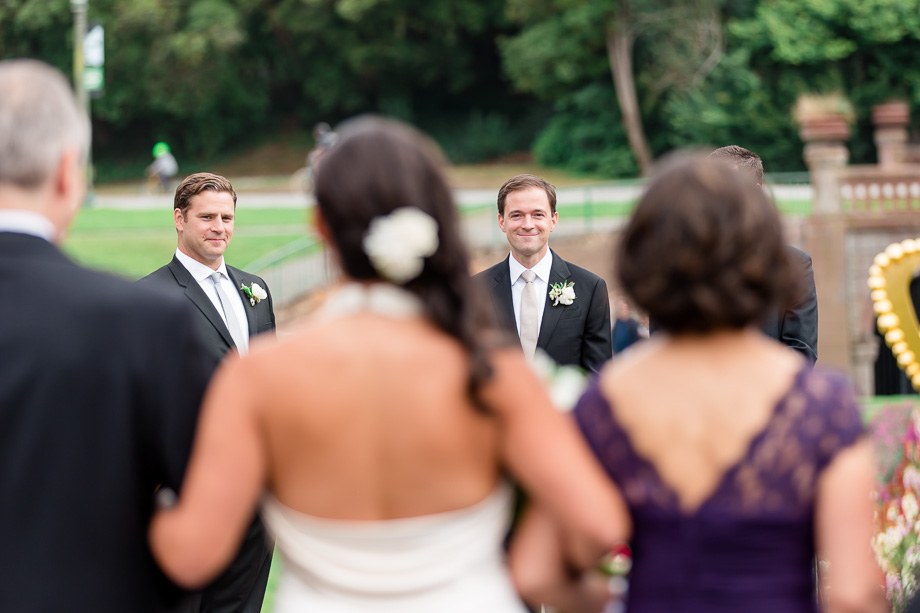groom watching the bride walking down the aisle