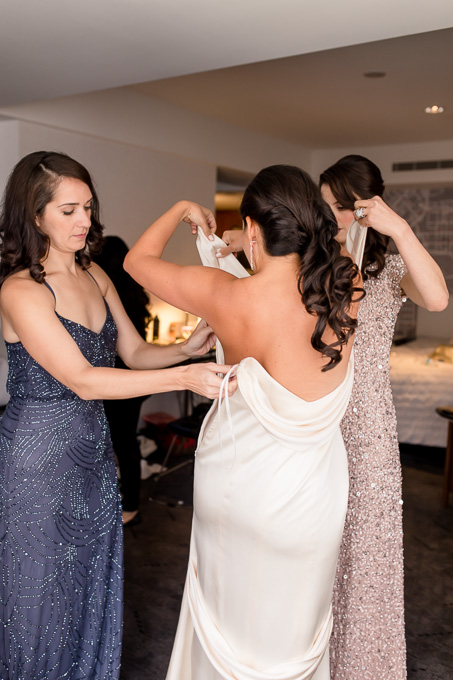 bride getting into her hollywood glamour wedding dress