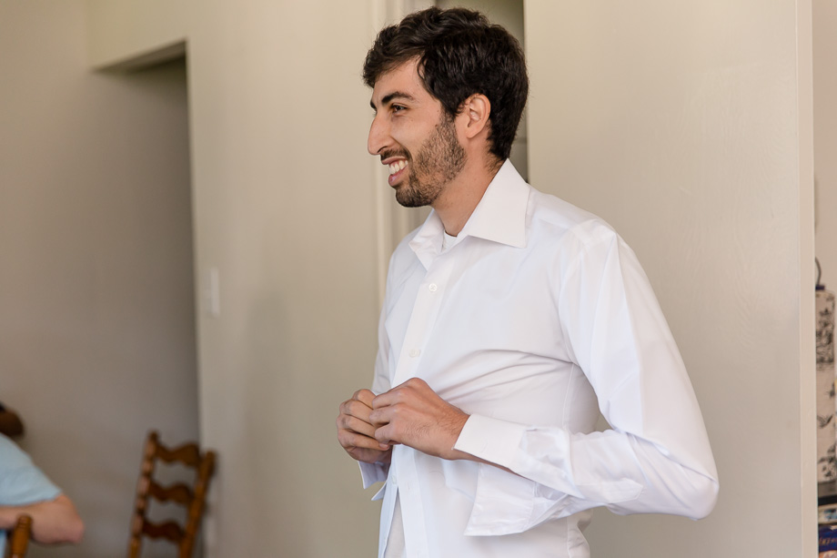 groom getting his shirt buttoned up