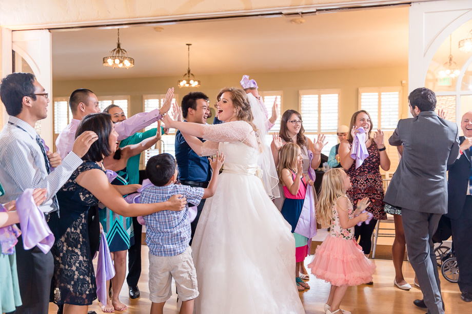 bride and groom hi-five their wedding guests during the grand entrance