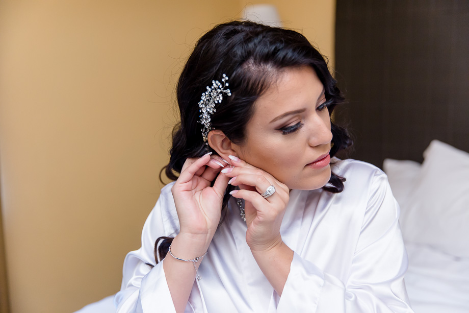 bride putting on her earrings