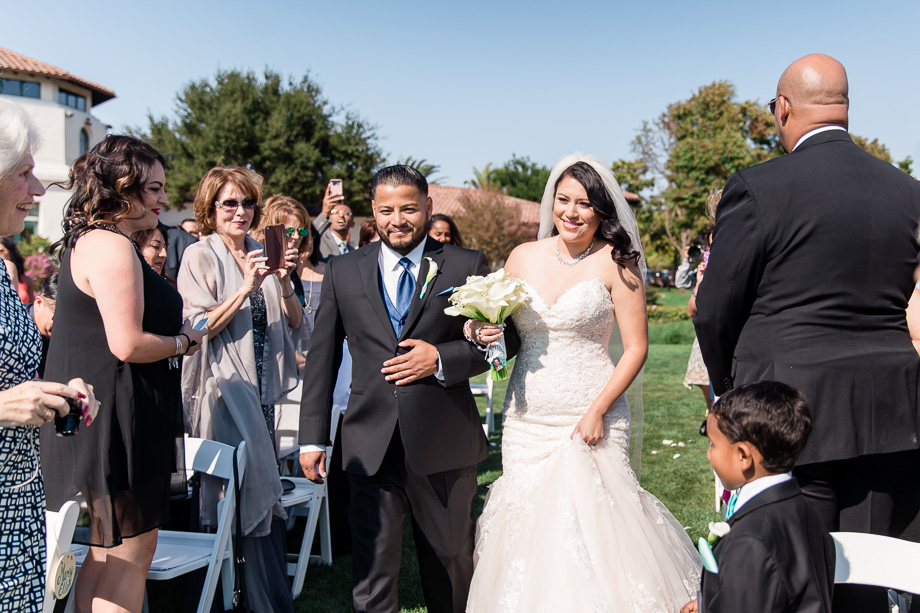 bride walking down the aisle escorted by her brother