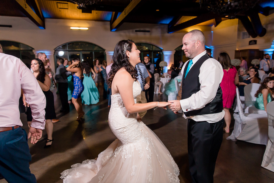bride and groom enjoy dancing with each other at their reception dance party
