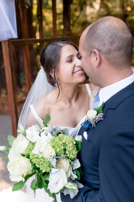 bride and groom portrait in front of their wedding arch
