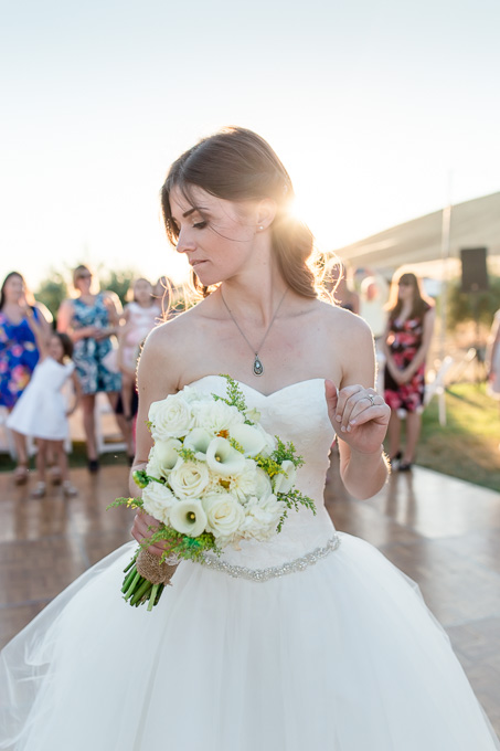bride tossing the bouquet during sunset