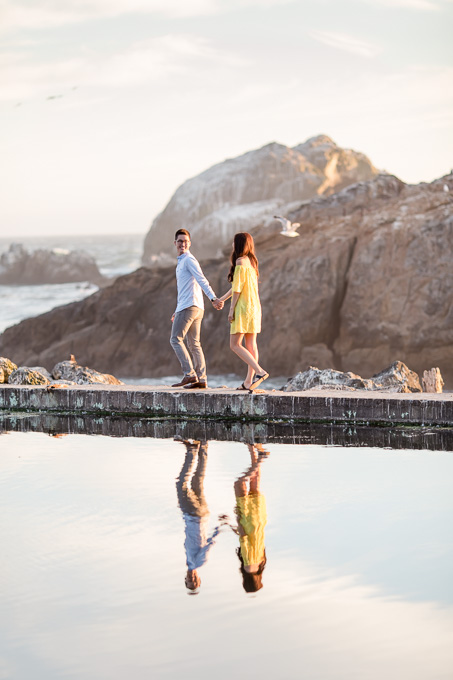 happy couple walking along the water